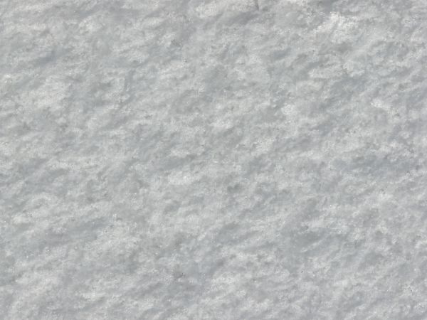 Rough ice texture, made up of bright white snow and dark, reflective chunks of ice.